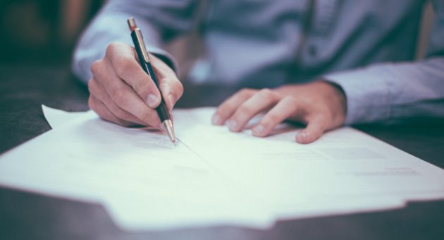 Man writing out a real estate purchase agreement