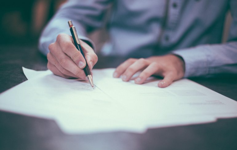 Man writing out a real estate purchase agreement