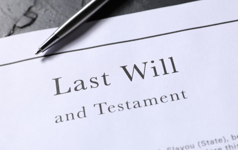 A close-up of a document titled Last Will and Testament with a silver pen resting on top.