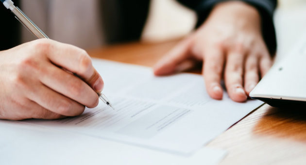 hand signing a legal paper