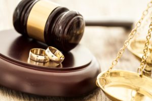 wedding rings and a gavel representing a prenuptial agreement