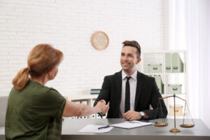 man and woman shaking hands over an asset purchase agreement