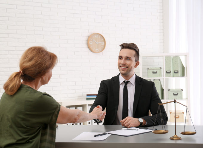 man and woman shaking hands over an asset purchase agreement