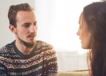 a young man and woman talking seriously