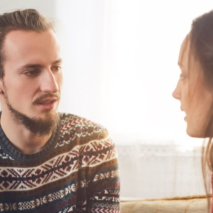 a young man and woman talking seriously