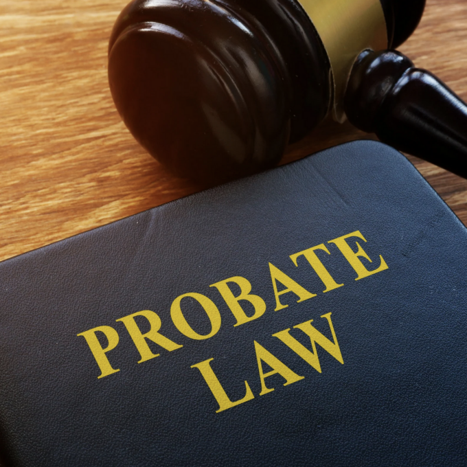 Close-up of a legal book titled “Probate Law” on a wooden desk beside a judge’s gavel and a pen