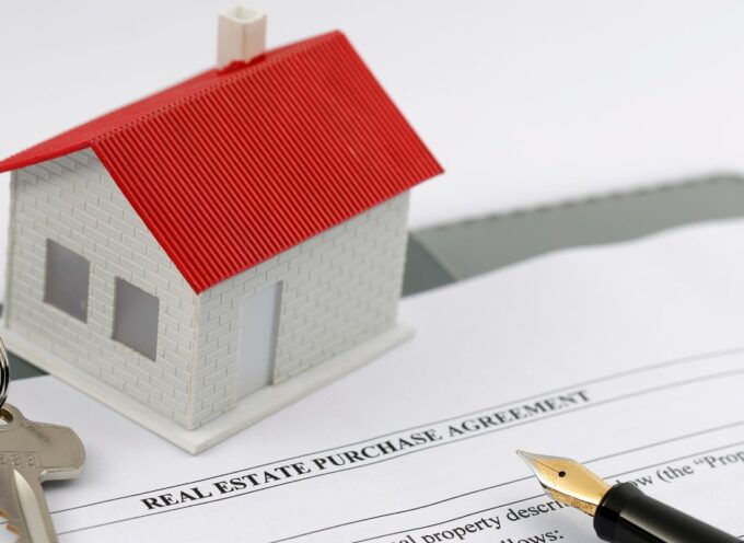 blank real estate agreement with a set of keys and plastic house