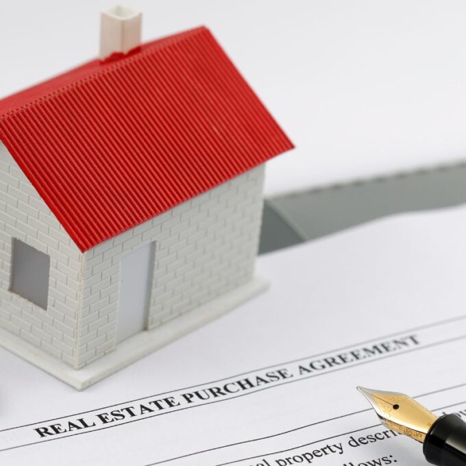 blank real estate agreement with a set of keys and plastic house