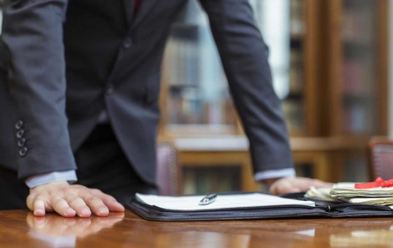 man standing up with hands on a desk