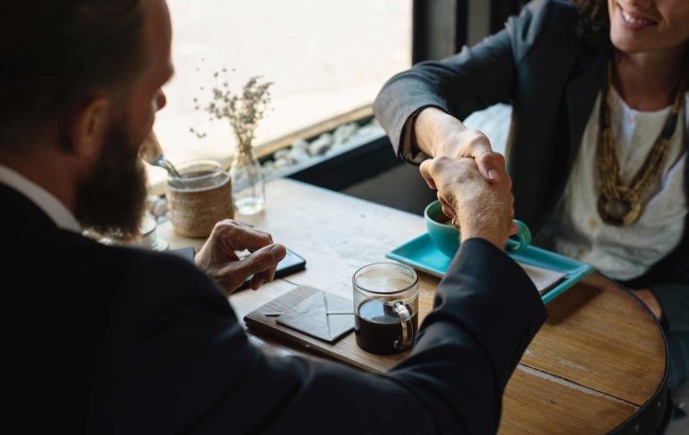 client and lawyer shaking hands over an agreement